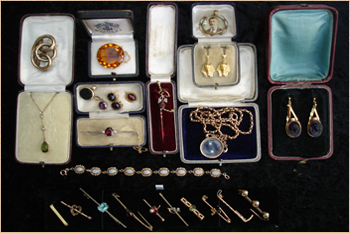 A tray full of various items of gold and stone set jewellery.